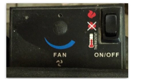 Close-up of the black fireplace control panel, with a fan dial on the left and an ON/OFF rocker switch on the right beside flame and thermostat symbols.