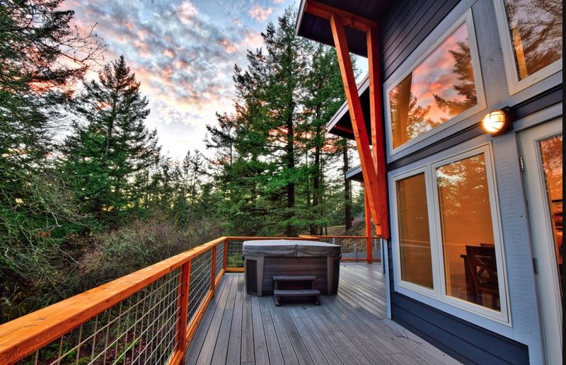 Hot tub on the large deck surrounded by evergreens