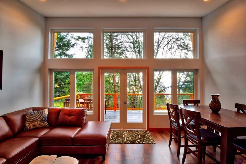 Living room with leather sectional below tall windows