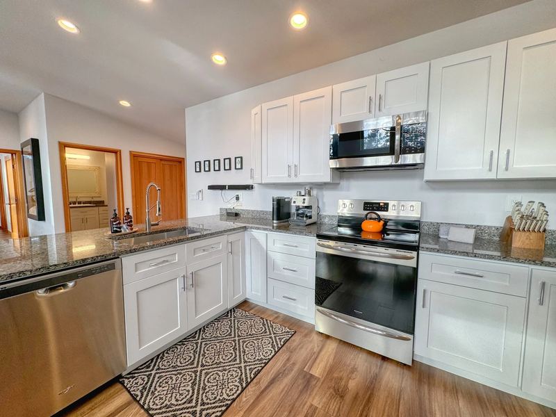 White kitchen with granite counters and stainless appliances