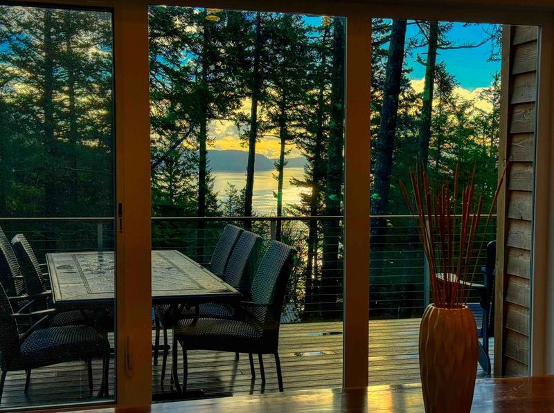 Deck dining table with water views at dusk