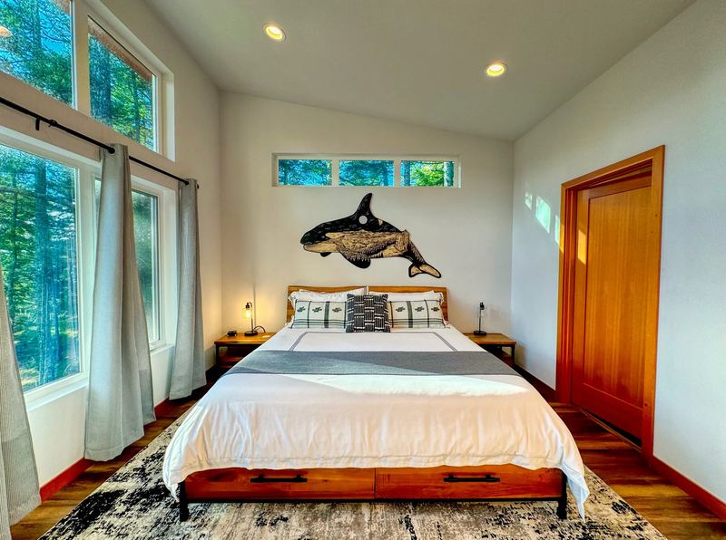 Primary bedroom with king bed and orca artwork